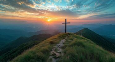 A cross on top of a mountain at sunset photo