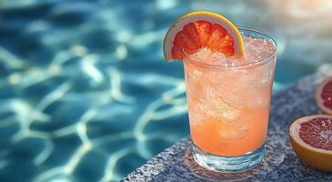 A glass of pink grapefruit juice with a slice of orange photo