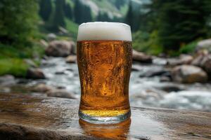 A beer glass sitting on a wooden table next to a river photo
