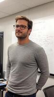 A man in glasses standing in front of a whiteboard photo
