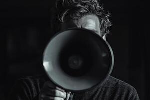 A man holding a megaphone in front of his face photo