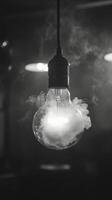 A black and white photo of a light bulb with smoke coming out of it