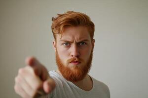 A man with a red beard pointing at something photo