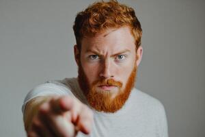 A man with red hair and beard pointing at the camera photo