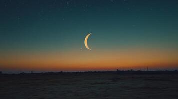 The moon and crescent are seen in the sky at sunset photo