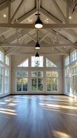 An empty room with lots of windows and wood floors photo