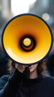 A person holding a yellow megaphone photo