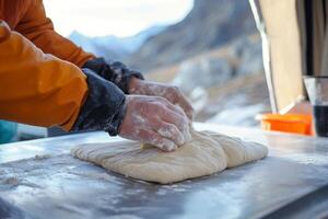 A person is kneading dough on a table photo