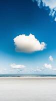 A lone person standing on a beach with a cloud in the sky photo