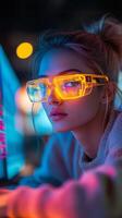 A woman wearing glasses and looking at a computer screen photo