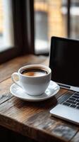 Coffee and laptop on wooden table photo