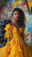 A beautiful woman in a yellow dress standing in front of a camera photo
