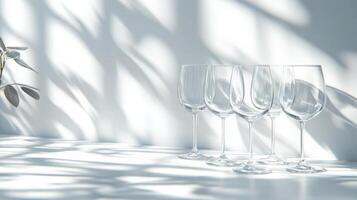 Three wine glasses sit on a table next to a vase photo