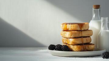 A stack of pancakes on a plate next to a bottle of milk photo