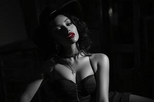 A woman in a black dress and hat sitting on a chair photo