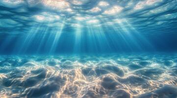 Underwater ocean floor with sunlight shining through the water photo