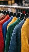 Colorful sweaters hanging on hangers in a store photo