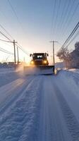 A snow plow driving down a snowy road photo