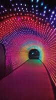 A tunnel with colorful lights and a walkway photo