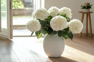 A vase of white flowers sitting on a wooden floor photo