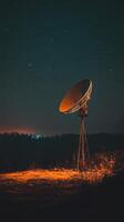 An old satellite dish on a hill at night photo