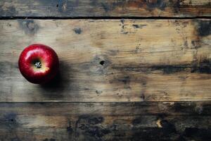An apple is sitting on top of a wooden table photo