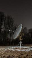 A satellite dish in the middle of a field photo
