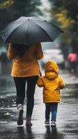 A woman and child walking in the rain under an umbrella photo