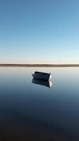 A boat floating in the water on a calm day photo