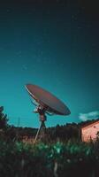 A satellite dish is seen in the night sky photo