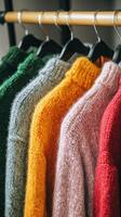 Colorful sweaters hanging on a rack photo