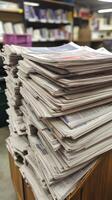 A stack of newspapers on a wooden table photo