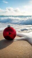 A red christmas ornament on the beach photo