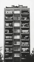 A black and white photo of a tall apartment building