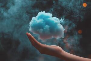 A hand holding a cloud in front of a dark background photo