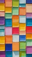 Colorful plastic boxes stacked up against a wall photo