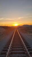 A railroad track is seen at sunset photo