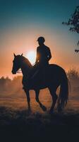 A silhouette of a person riding a horse at sunset photo
