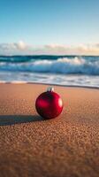 A red christmas ornament on the beach photo
