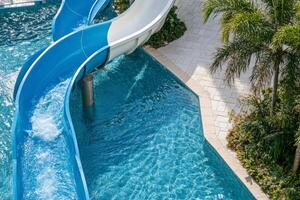 A blue water slide in a pool photo