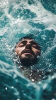 A man swimming in the ocean with his eyes closed photo