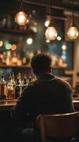 A man sitting at a bar with bottles of alcohol photo