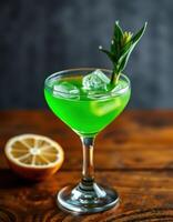 Vibrant green cocktail served in an elegant glass with fresh lemon and herbs on a wooden table photo