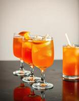 Refreshing orange cocktails served on a dark wooden table in soft lighting during a social gathering photo