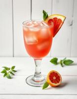 Refreshing citrus drink garnished with mint and grapefruit by a wooden backdrop in bright light photo