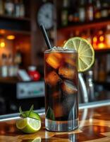 Refreshing dark soda cocktail with lime and mint on a wooden bar counter in a cozy setting photo