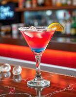 Colorful cocktail served in a stylish glass at a vibrant bar setting during evening hours photo