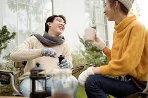 Enjoying Warm Drinks and Conversation in a Sunny Outdoor Garden During Autumn Afternoon photo