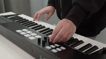 Midsection of woman dancing while playing keyboard. Closeup of female pianist using wearing black jacket. She is enjoying music at studio. video