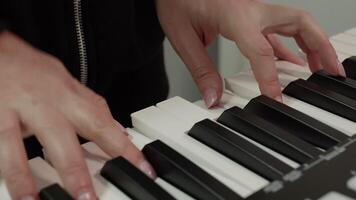 Capturing the elegance and precision of a female musician's hands skillfully playing a striking white and black electronic keyboard, producing beautiful melodies and rhythms video
